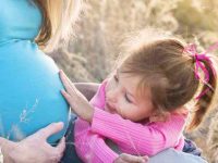 ילדה נוגעת בבטן של אמא שלה