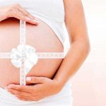 אישה בהריון נוגעת בבטן שלה