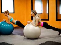 שתי בנות עושות פלאנק על כדור פיטבול